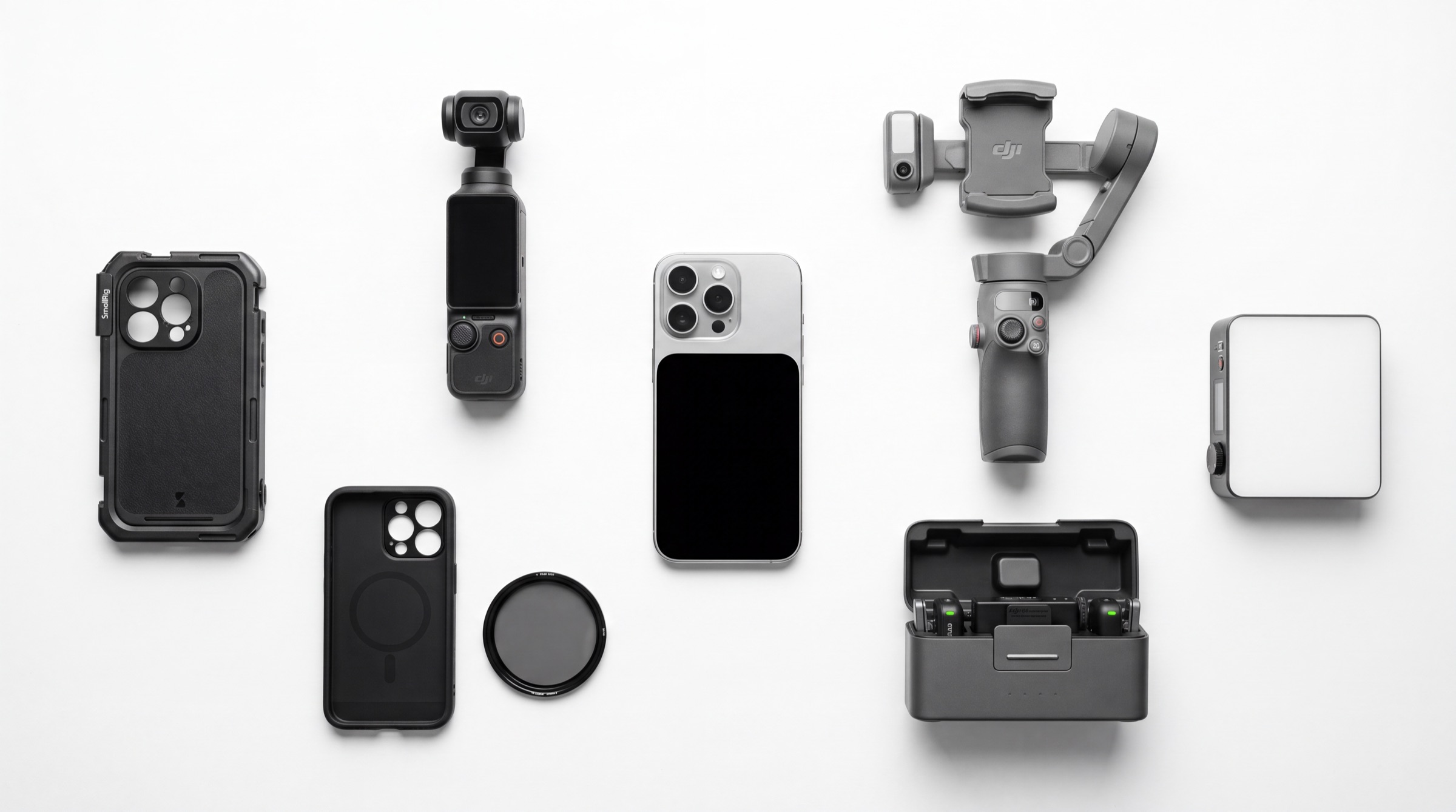 The full Fusion Weddings kit laid out: iPhone Pro, DJI Osmo Pocket 3, a stabiliser gimbal, cinema filters, a wireless mic kit, a protective rig case and a pocket light